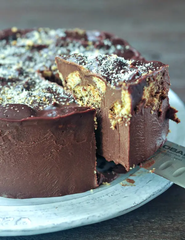 a slice of chocolate biscuit cake being lifted out of the cake with the knife that sliced it