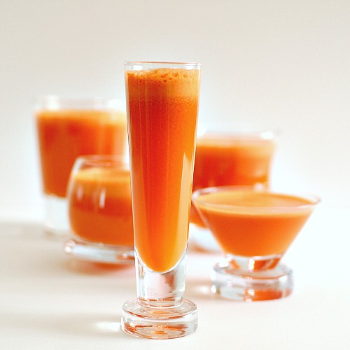 several shot glasses with ginger carrot juice