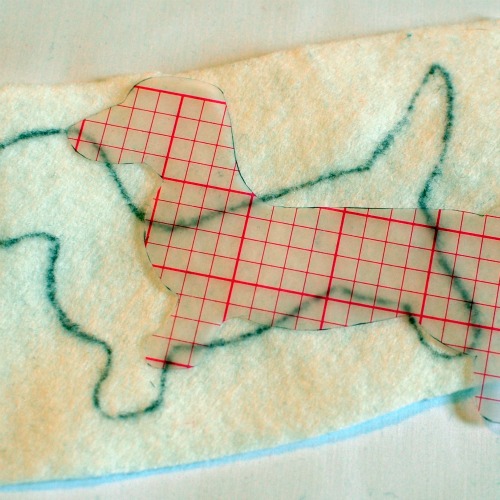 A template of a dachshund drawn onto a piece of felt.