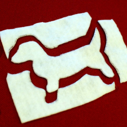 A dachshund dog shape cut out of a piece of felt.