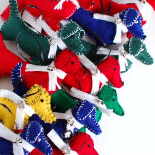 A pile of colorful handmade felt dachshund ornaments, ready to hang on the tree!