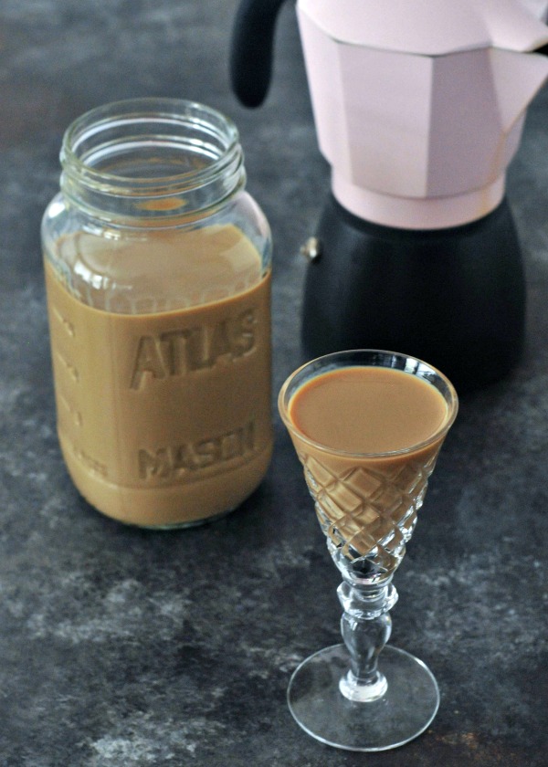 Homemade Baileys Liqueur in a crystal glass, espresso pot in background