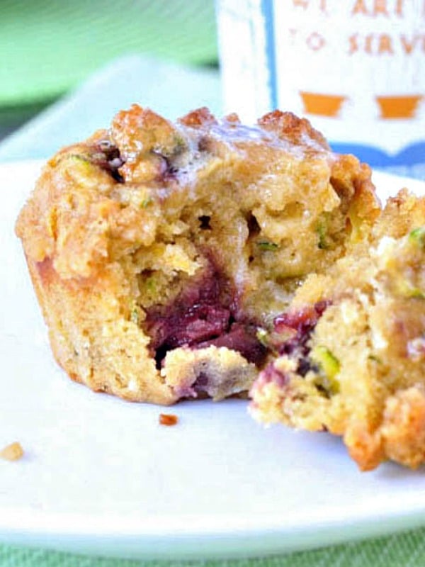 cherry zucchini muffin in half, showing cherries inside; melted butter on top