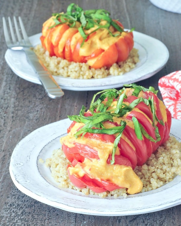 Cheesy Roasted Hahow to hasselback - bright red tomato sliced hasselback style, with melty cheese and fresh chopped basil, served over quinoa