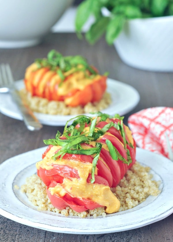 Cheesy Roasted Hasselbackhow to hasselback - bright red tomato sliced hasselback style, with melty cheese and fresh chopped basil, served over quinoa