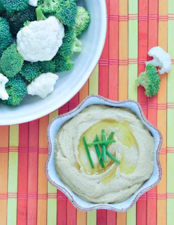 Bright Lemon Miso Hummus in a bowl with broccoli and cauliflower for dipping