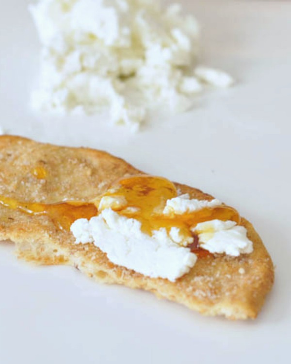 Vegan Goat Cheese spread on a cracker with maple syrup