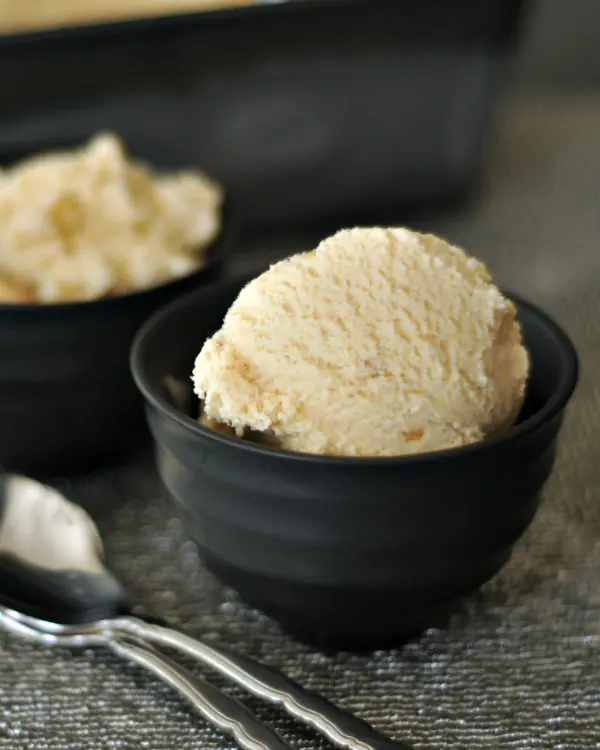 tan colored ginger maple miso ice cream in a bowl, spoon on the side