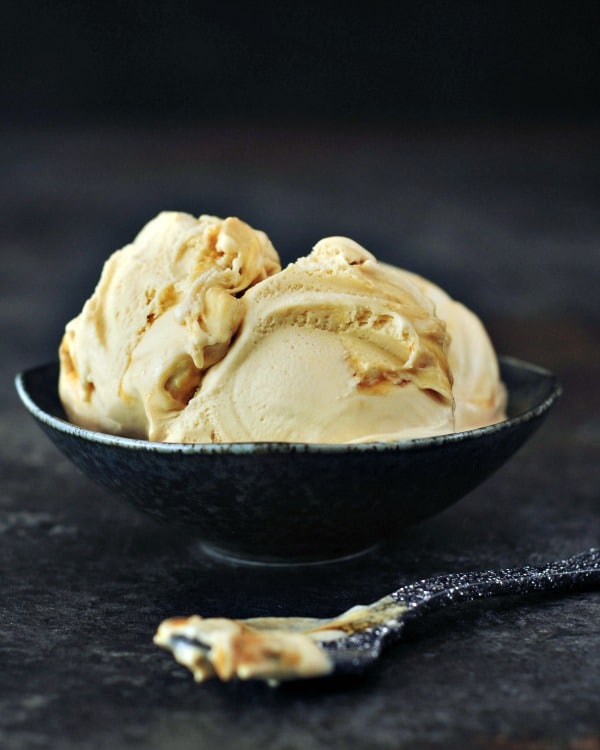 tan colored ginger maple miso ice cream in a bowl, spoon on the side