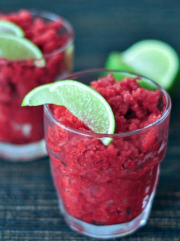 Cran Raspberry Icy Granita in a glass, garnished with a lime wedge