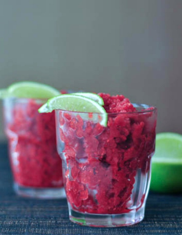 Iced Cran Raspberry Granita in a glass, garnished with a lime wedge