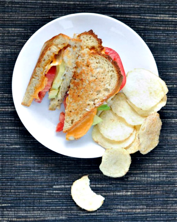 Salt and vinegar grilled cheese served on a plate with potato chips on the side