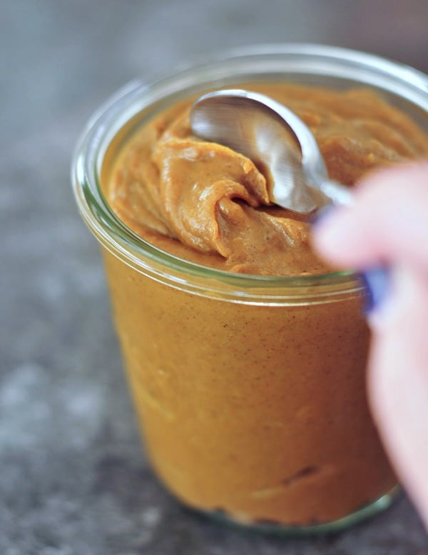 a spoon going into a jar of Pumpkin Caramel Sauce 