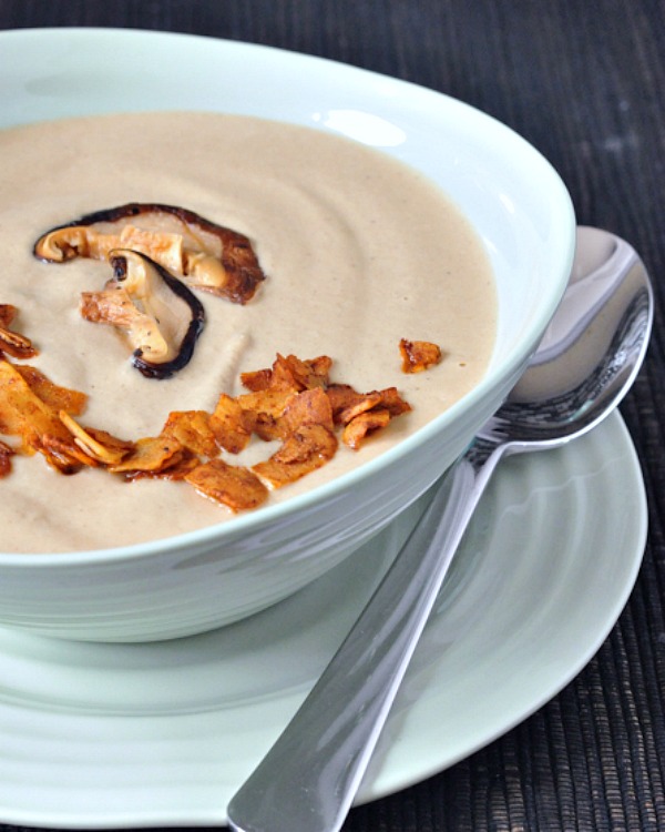 Vegan mushroom soup in a light blue bowl, topped with coconut bacon bits