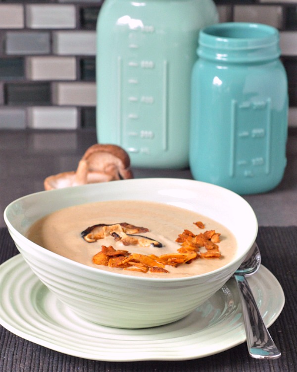 roasted mushroom bisque in a bowl, fresh shiitake mushrooms in background