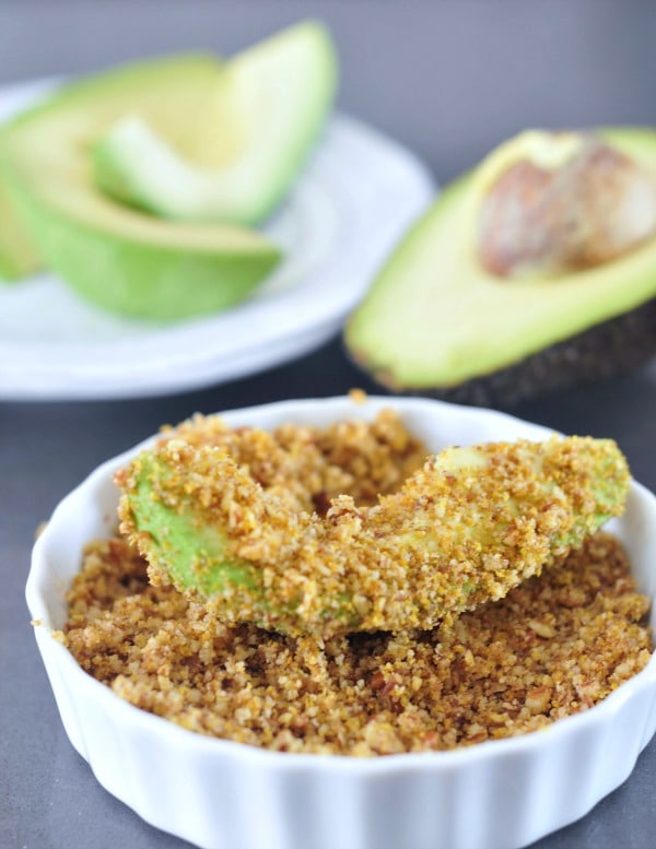 avocado slices covered in breadcrumbs in small white dish