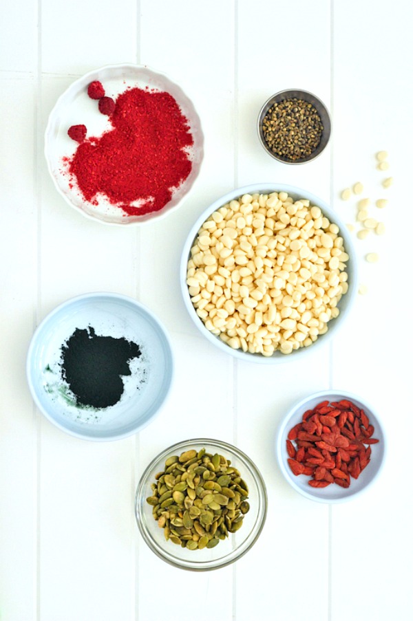 Ingredients for white chocolate bark: raspberry powder, hemp seeds, pepitas, white chocolate, blue spirulina powder, goji berries.