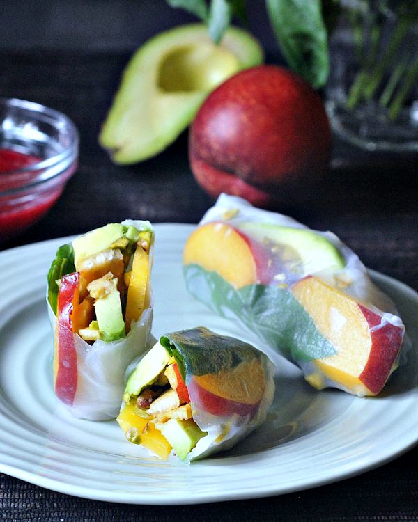 tempeh and fruit summer rolls, plated with raspberry sauce