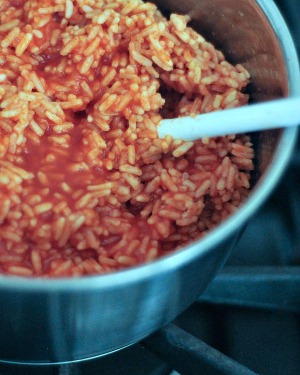 Spanish rice cooking in a saucepan on the stove