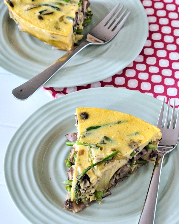 two slice of vegan mushroom quiche on pastel green plates