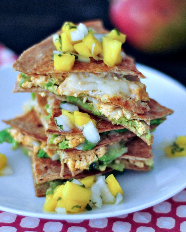 Chipotle quesadilla triangles with mango salsa stacked on a plate