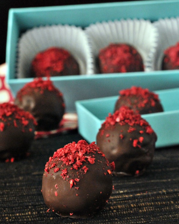 chocolate truffles with raspberry dust in a small blue gift box