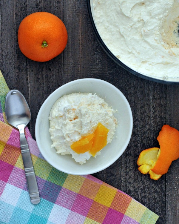 overhead view of Jello Salad in a white bowl, topped with fresh orange segments