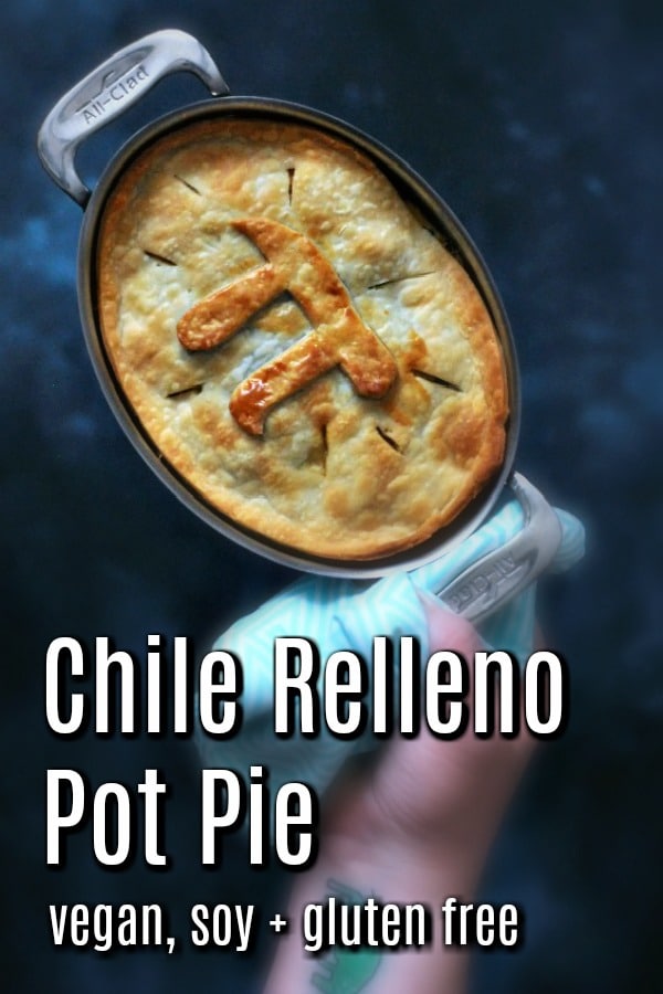 a hand holding a single serving ramekin of Vegan Chile Relleno Pot Pie, with a Pi symbol in the top crust