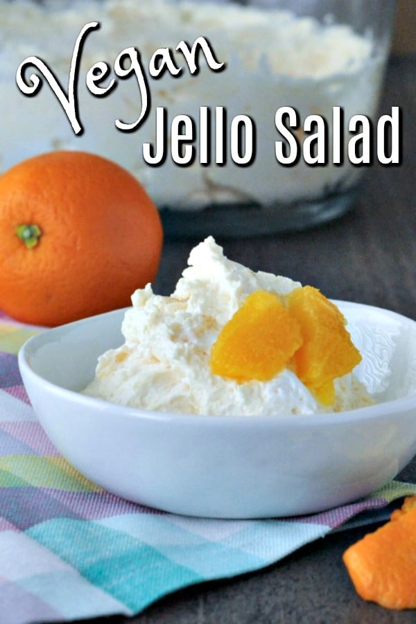 portion of Vegan Jello Salad in a small white bowl, garnished with fresh orange segments