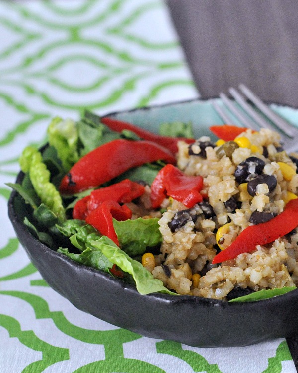 Veggie Bean Burrito Bowl in a small shallow bowl: greens, cauliflower rice, red peppers, corn, beans