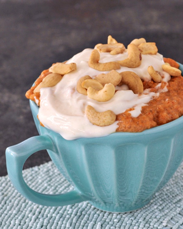 red curry coconut chia pudding and cashew cream, topped with cashews, served in a mug