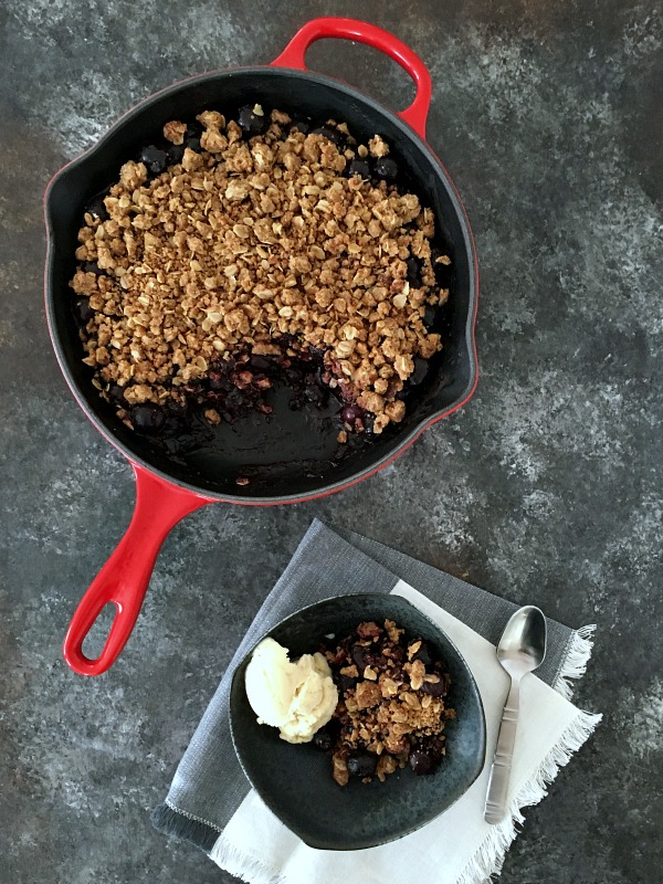 chocolate and cherry crisp in in skillet and bowl with ice cream