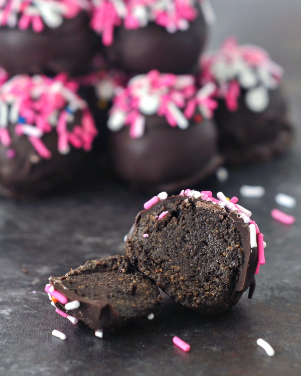 Chocolate Covered Oreo Cashew Truffles in a stack, one sliced open