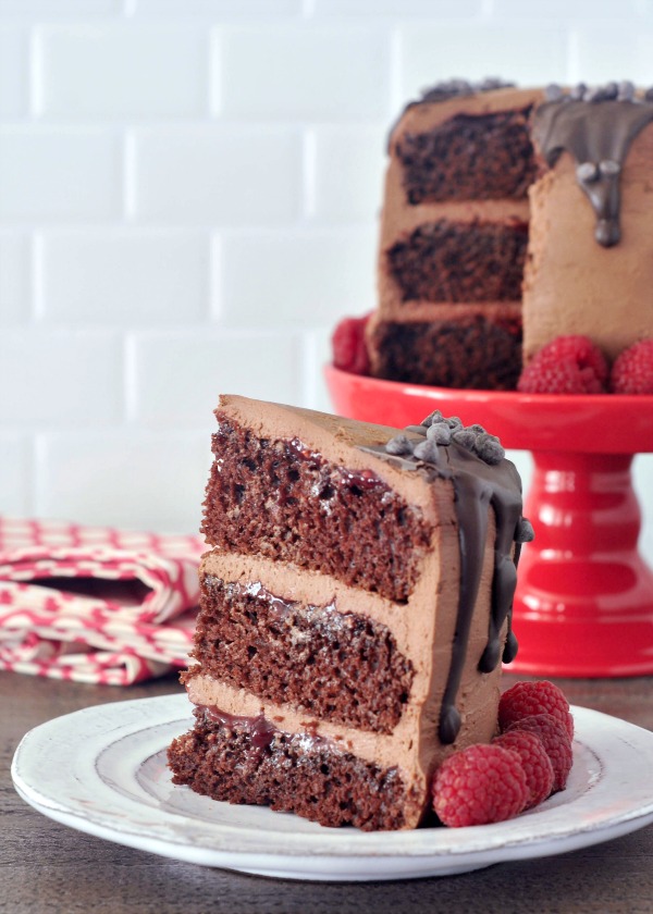 whole Delectably Rich Vegan Chocolate Mousse Cake with one slice on a plate in front