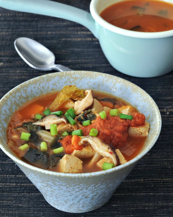 bowl of Super Flavorful Instant Kimchi Noodle Soup - tofu, mushrooms, broth, noodles, kimchi, scallions