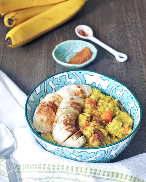 a breakfast bowl of kitchari and sliced bananas, topped with cinnamon.