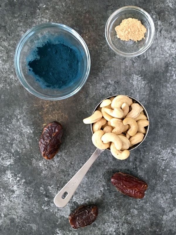 overhead view of vanilla mint cashew milk: blue spirulina powder, maca, pitted Medjool dates, cashews