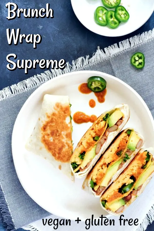 Two ranchero style breakfast crunchwraps sliced in half and arrranged on a white dish. Crunchwrap is filled with scrambled egg, beans, ranchero sauce, jalapenos.