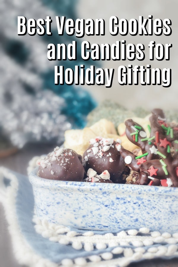 a white ceramic dish with blue splatter paint holds holiday cookies and candies, like chocolate covered pretzels shaped as reindeer, peppermint oreo truffles, shortbread star shaped cookies