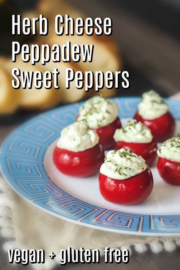 round red peppadew sweet peppers filled with herb cheese (Boursin style) on a white plate with a light blue Greek Key border design