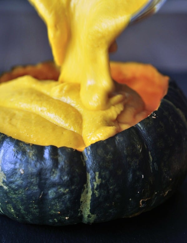 bright yellow Spicy Chipotle Kabocha Dip being poured into the squash shell