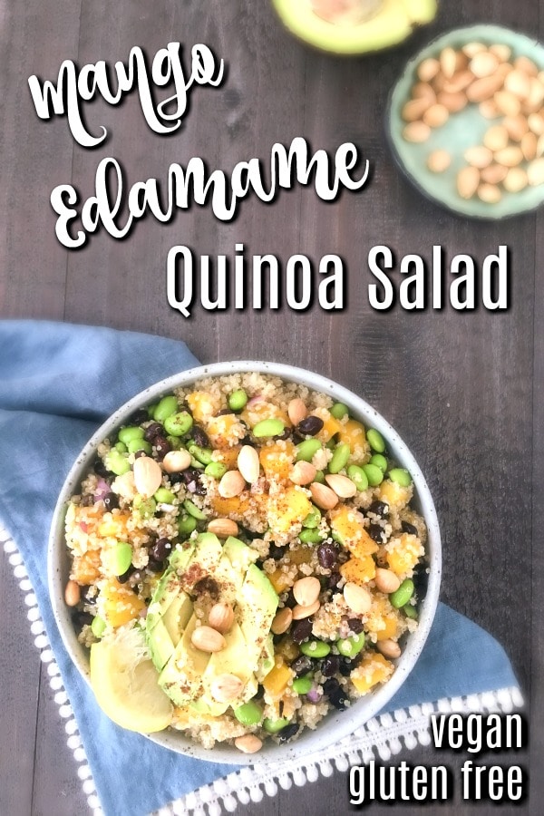 best potluck recipe and great meal prep recipe - overhead view of Mango Edamame Quinoa Salad in a serving bowl with cubed avocado and a squeezed lemon slice, light blue cloth napkin underneath bowl. a small bowl of marcona almonds and the other half of avocado is next to the bowl.