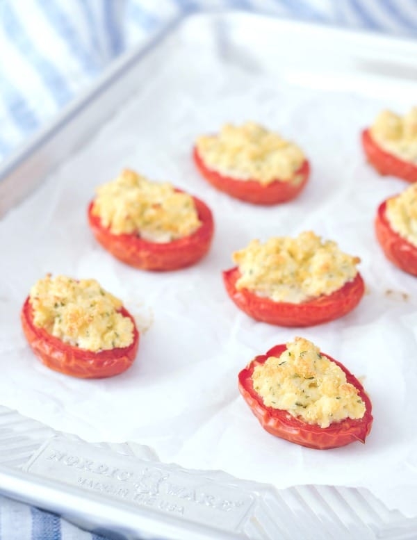 Vegan Stuffed Tomatoes - broiled ricotta filled tomato halves arranged on a parchment lined baking sheet