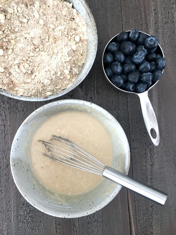 Healthy Coffee Cake process shot: one bowl of dry ingredients, one bowl of wet ingredients, one cup of fresh blueberries