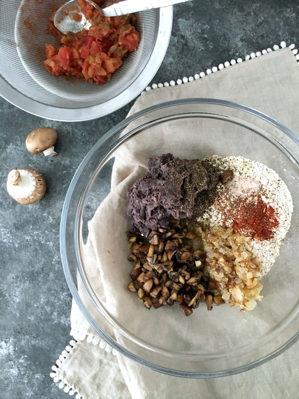 How To Make A Veggie Burger That Doesn't Fall Apart: glass bowl with veggie burger ingredients - black beans, mushrooms, oats, salsa, spices