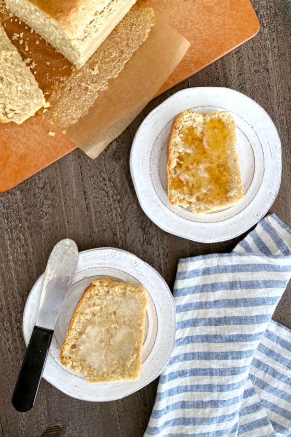 slices of peanut butter bread on plates, butter knife and loaf of bread on the side