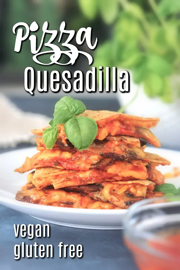 a stack of pizza flavored quesadilla slices on a white plate, fresh basil leaves on top