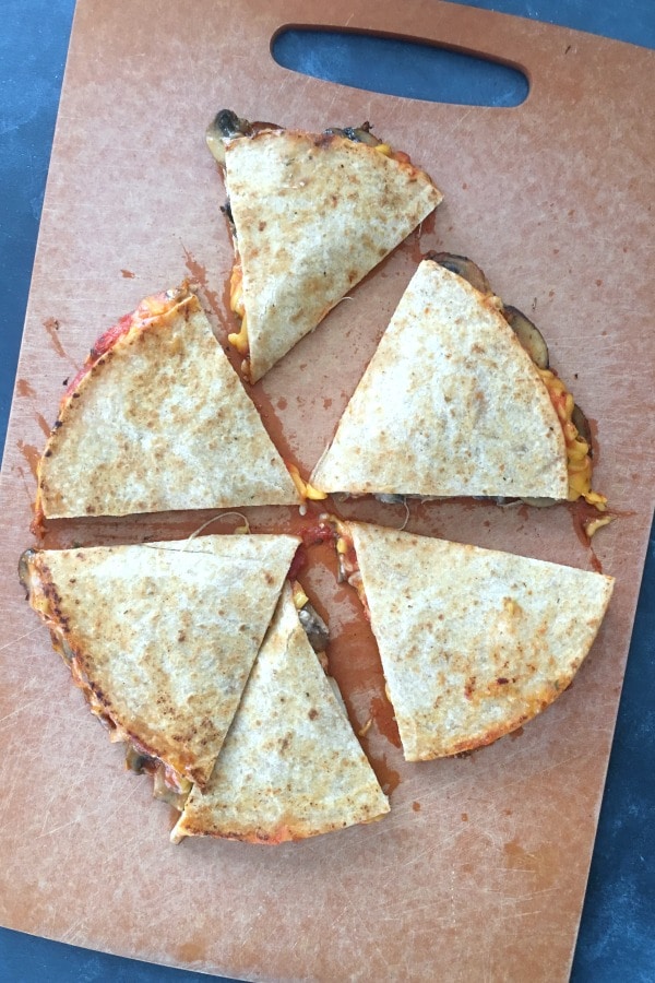 overhead view of quesadilla on a cutting board, cut into 6 triangles