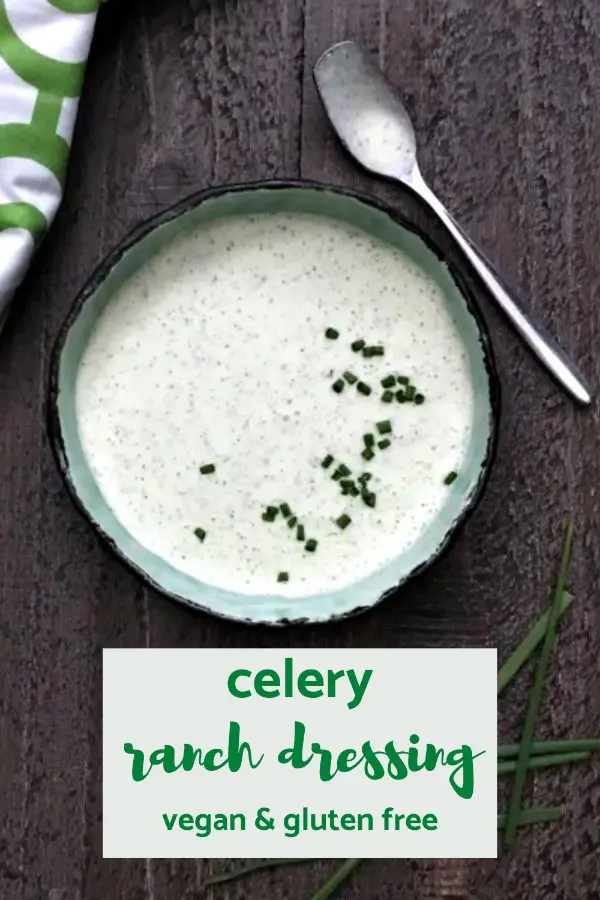 overhead view of vegan ranch dressing in a bowl, topped with chopped chives. green and white napkin and small spoon next to bowl.