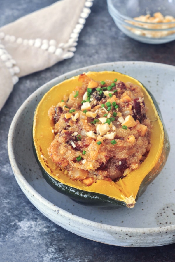 vegan stuffed acorn squash: a mixture of amaranth grain cooked in vegetable broth with dried apricots and nuts served in a cooked acorn squash half